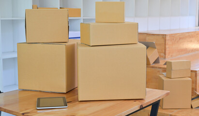 Brown paper box and tablet on the desk in the office store,Parcel transport concept.