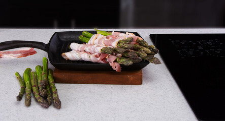 Fresh Asparagus Wrapped in Bacon Ready for Grilling on Iron Pan..