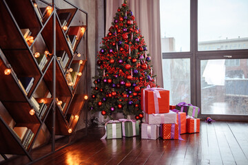 Winter decoration. decoration of the shelf for the new year or Christmas. candles, Christmas tree, books, bows and bumps