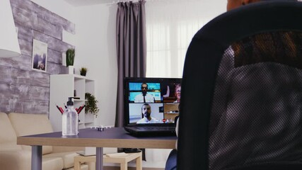 Young woman during a video call using laptop from home office.
