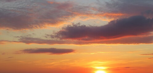 Naklejka na ściany i meble Beautiful panoramic view on orange burgundy sunset in the sky, natural background
