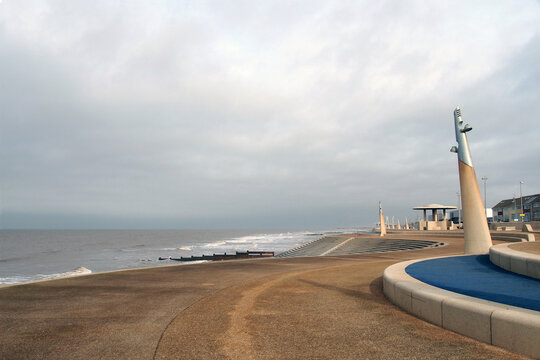 The curved promenade along the seafront at cleveleys in blackpool with steps leading to the beach