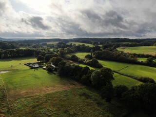 aerial view of lovely countryside with cloud and sunshine and white cottage