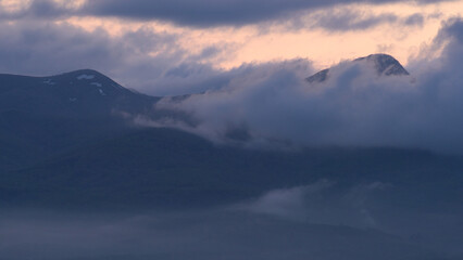 薄暗い夕日の雲と山並み