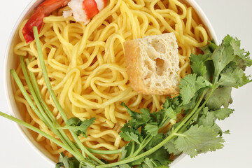 Fresh yellow egg noodle prawn tofu coriander leaf in bowl on whit background