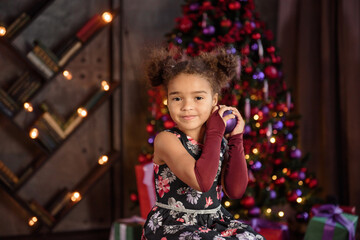 Fototapeta na wymiar Merry Christmas! Cute little child girl is decorating the Christmas tree.