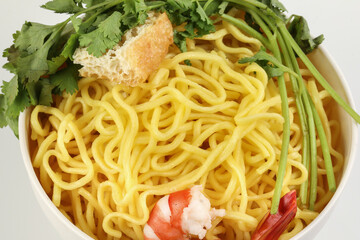 Fresh yellow egg noodle prawn tofu coriander leaf in bowl on whit background