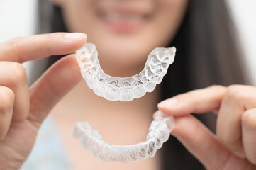 Woman show orthodontic silicone trainer. Mobile orthodontic appliance for dental correction. tooth whitening systems.