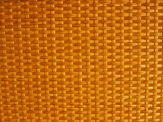 Wicker rattan mat in warm golden colors.Weave wood pattern for background.Handcraft natural wicker texture close up with copy space.