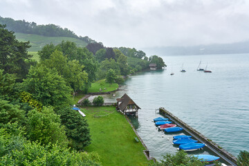 Landscape of Thun Lake on a rainy and foggy day. Taken in Spiez, Swiss Alps, Switzerland