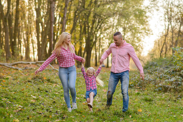 Fototapeta premium Father, daughter and mother walking outdoors. Happy family.
