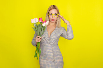 Blonde woman in plaid dress holding tulips bouquet