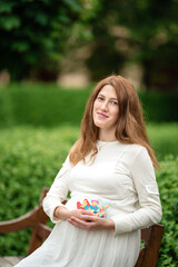 Pregnant woman holding a letter from plastic.