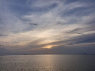 Sunset in evening at the sea with cloudy and blue sky in background in Thailand
