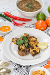 Fried oxtail served on a table with lemon slices.