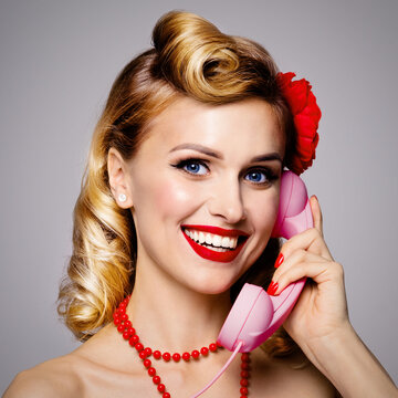 Face portrait photo - happy woman holding telephone tube, saying allo. Excited pin up girl. Blond caucasian model at retro and vintage concept. Grey color background. Square composition.