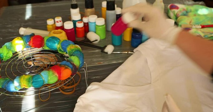 Woman applying tie dye technique to t shirt