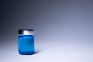 Little bottle with blue liquid on white-gray background. Isolated. Board games. Cure - medicine, vaccine. Coronavirus or covid-19 - pandemic. High quality photo