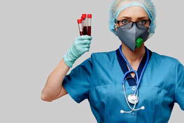 medical doctor nurse woman wearing protective mask and gloves - holding virus blood test tube