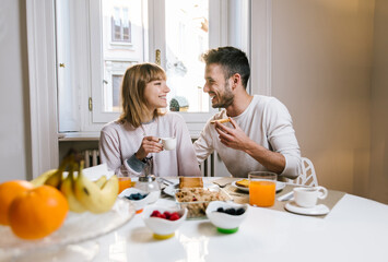Obraz na płótnie Canvas Happy couple having healthy breakfast together at home