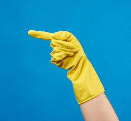 yellow rubber glove for cleaning dressed on a female hand