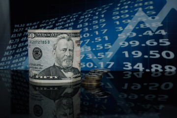 on a glass table in a twisted form is the American dollar against a background of economic graphs...