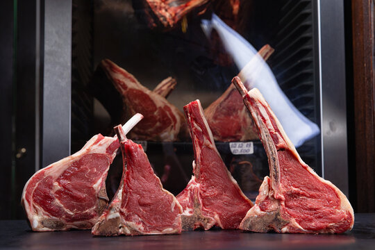 various raw steaks on a background of dry aging cabinet