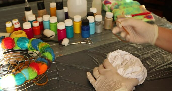 Woman applying tie dye technique to t shirt