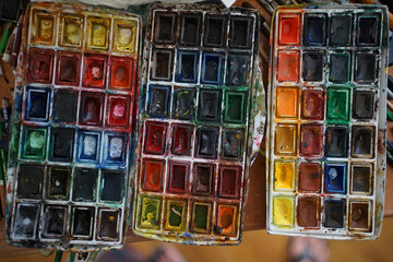 Top shot of heavily used watercolor box palette by professional artist with 72 different color shades