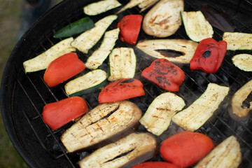 Grilled Vegetables (red pepper, zucchini, eggplant). ook prepares vegetables on the grill