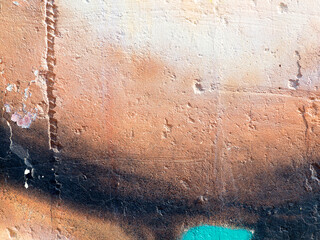 Shabby building facade with damaged plaster. Painted distressed wall surface. Grungy wide concrete...