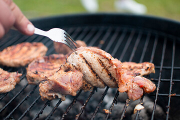 Juicy meat with grilled vegetables (Steak, pork, beef, pepper, salt, grill). The cook pours beer on the juicy meat