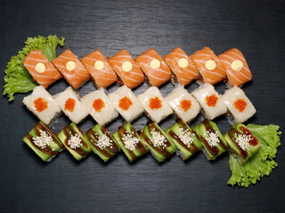 Set of three rolls on a black wooden background. Three dragons sushi set