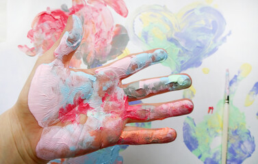 the imprint of a human hand with colorful paint and paint on the hand