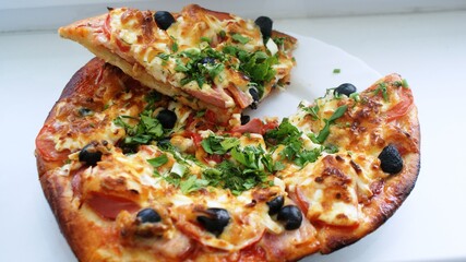 fresh pizza on a plate on the windowsill