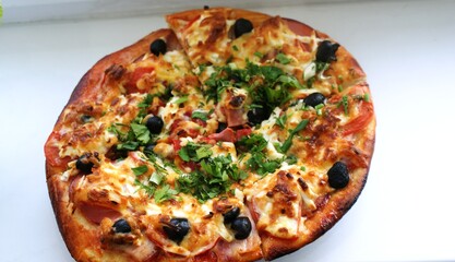 fresh pizza on a plate on the windowsill