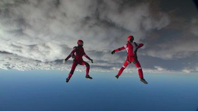Two sports parachutist build a figure in free fall. Extreme sport concept.
