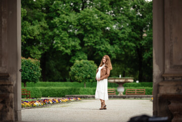 pregnant brunette woman at an old building gazebo.