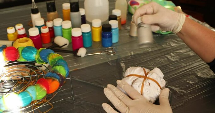 Woman applying tie dye technique to t shirt