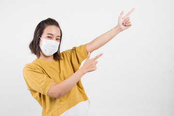 Young happy Asian woman wearing hygienic mask to prevent infection corona virus Air pollution pm2.5 she wearing a yellow sweater shoot in shot isolated on white background © Chatsiri