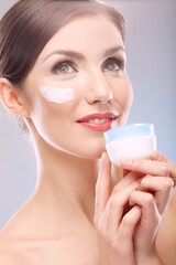 close up beauty portrait of smiling woman holding jar cream.