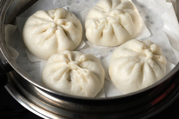 Fototapeta na wymiar Steamed BBQ pork bun, also know as Baozo, is a type of filled bun or bread-like dumpling in various Chinese cuisines.
