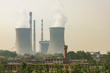 Xian, China - May1, 2010: Cooling towers and chimneys of power plant under gray and yellowish...