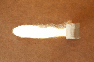 Recycle brown torn open paper with space for text on white background. Coiling torn strip of paper. Torn strip of paper with uneven, torn edges. 