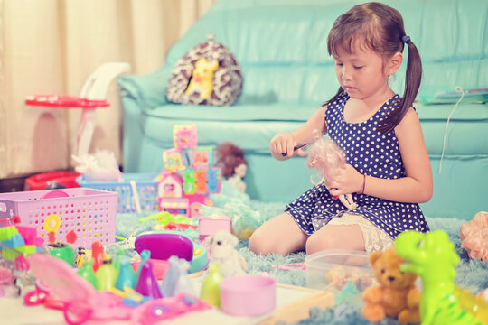 Child little girl play toys disorderly mess in living room a dirty or untidy state of toy and doll at home