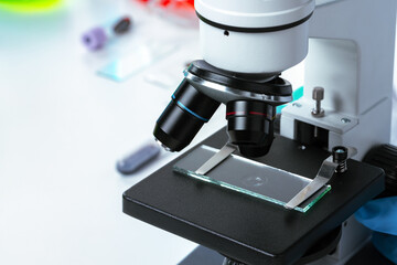 Close up photo of a microscope lenses examining glass sample