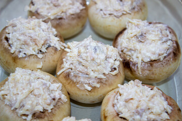 Stuffed mushrooms stuffed with cheese, mushroom stalks and onions. In a baking dish.