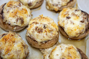 Stuffed mushrooms stuffed with cheese, mushroom stalks and onions. In a baking dish.