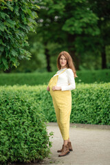 Fototapeta premium Beautiful pregnant girl walking in the Park.