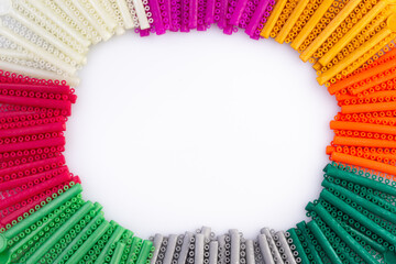 group of colorful O-rings for use with brackets for orthodontics dental.O-rings arranged in a circular shape with a white background area in the middle.